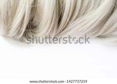 Beautiful hair. Light brown hair. Hair is gathered in a bun on a white background. With free space for text. For a poster or business card.