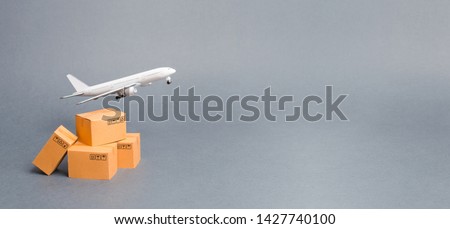 Airplane and stack of cardboard boxes. concept of air cargo and parcels, airmail. Fast delivery of goods and products. Cargo aircraft. Logistics, connection to hard-to-reach places. Banner, copy space Royalty-Free Stock Photo #1427740100
