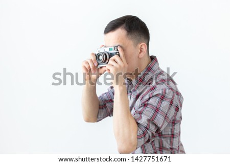 Vintage, photographer and people concept - handsome asian man with retro camera over white background