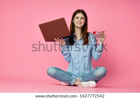 woman smiling sits with a laptop in hand