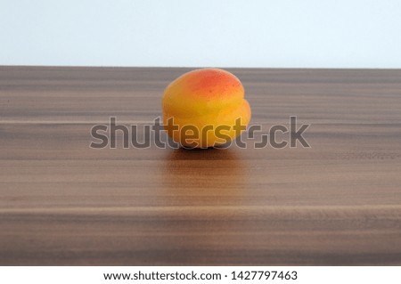 Red apricot on a brown wooden table background. Space for text.