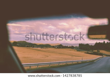 View from windscreen. Driving a car on mountain road during sunset. Nature of Norway