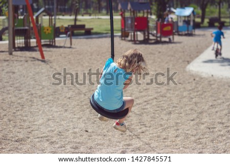 Little girl riding ropeway on playground