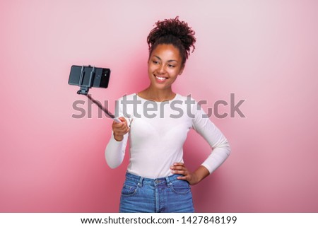 Young girl holding mobile phone takes a picture selfie - Image