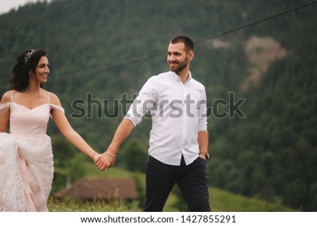Groom and bride walking hougt the Carpathian mountains