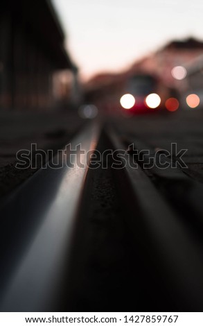 Photo of a close up railways and a out of focus tram in the background