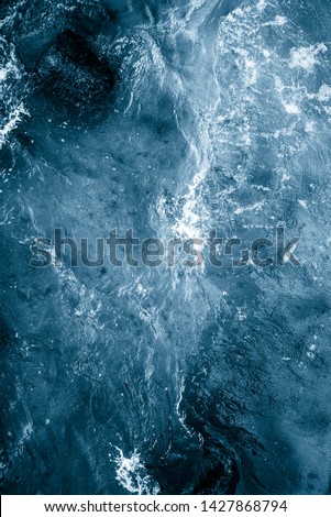 Deep blue white ocean water waves from above. Foam splash. Stormy sea surface.
