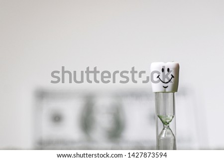 Tooth,dollar and hourglass on a white background.