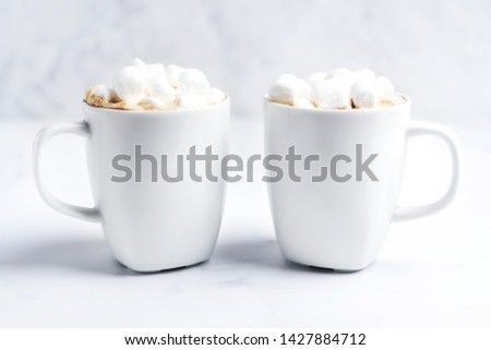 Romantic cozy desk top with two cups of coffee with marshmallows on marble table. Close-up. Space for text .