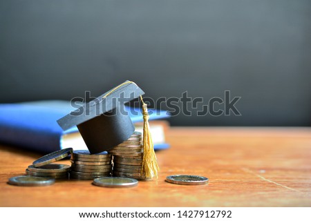 hat graduation model on money coins saving for concept investment education and scholarships Royalty-Free Stock Photo #1427912792