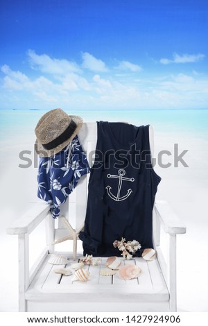 beach chair with clothes ,shell, hat, pants, starfish  by the ocean. vacation in the tropics


