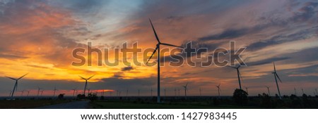 Aerial view of wind turbines in beautiful sunset. Production of clean energy without pollution for the environment. Banner background

