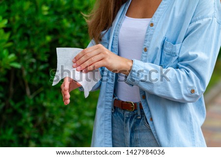 Using antibacterial wet wipes for disinfection hands outdoors  Royalty-Free Stock Photo #1427984036
