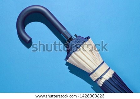 Umbrella handle hook on blue background. Top view, minimalism