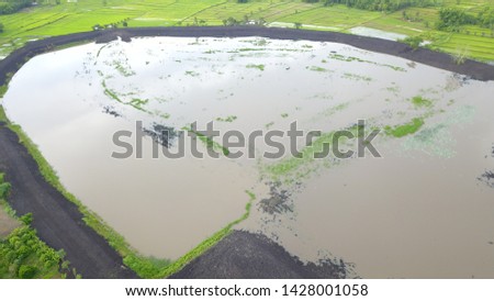 A large pond with black roads around