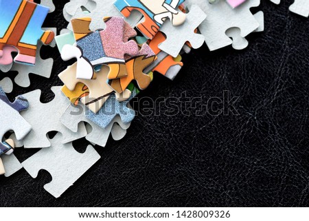 Children's puzzles scattered on a dark surface close-up