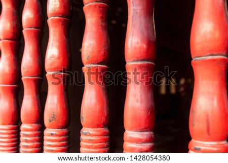 Red wooden sculpted decorative pillars with traditional engravings in the Temple of Literature (Quoc Tu Giam), Hanoi, Vietnam.