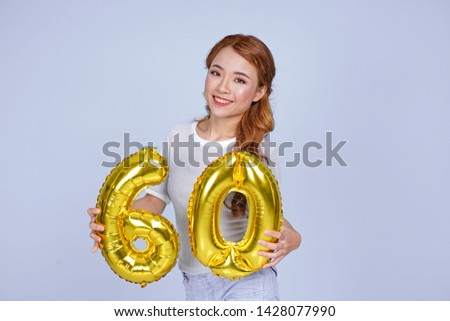 Asian young attractive beautiful young girl holding metallic foil balloon number
