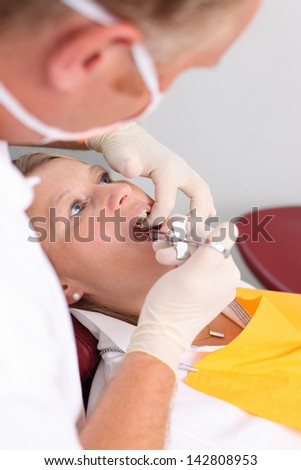 Dentist giving injection for anesthetizing his patient
