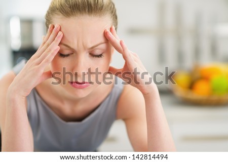 Portrait of stressed young housewife in modern kitchen Royalty-Free Stock Photo #142814494