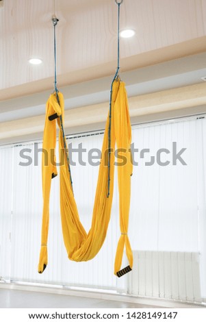Yellow fly yoga hammock hang on the white background in gym