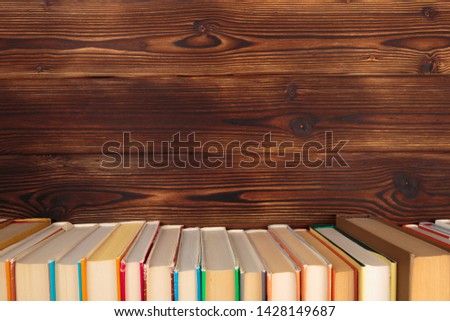 Stack of books on a wooden background.Education. - Image 