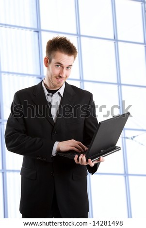 A shot of a caucasian businessman carrying a laptop working in an office