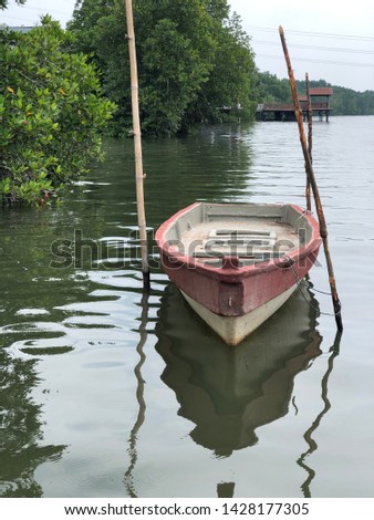 Wooden boat on water with nature background.