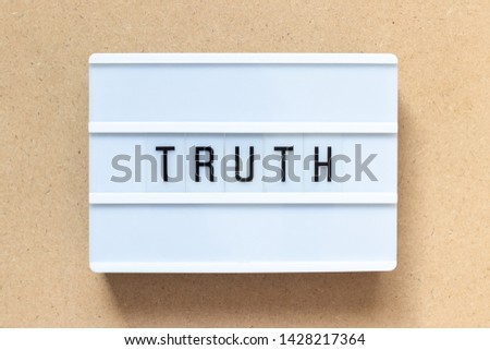 White lightbox with word truth on wood background