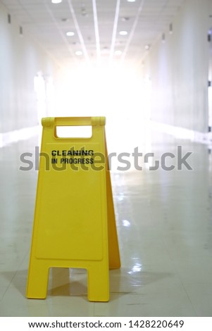 The yellow caution sign to allert the people, the cleaning is in progress to prevent the accident in the hallway.
