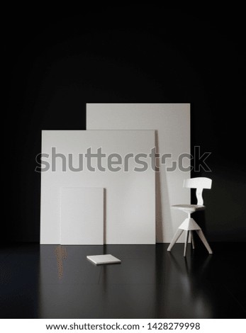 Pictures and chair in black studio with atmospheric lighting