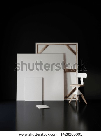 Pictures and chair in black studio with atmospheric lighting