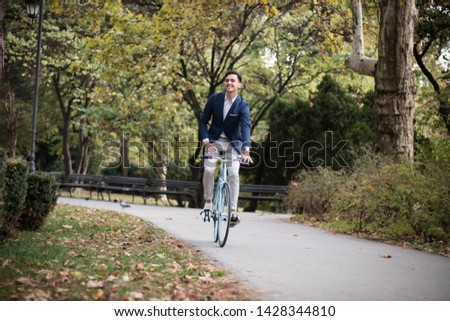 Young elegant businessman travels to work by bike.