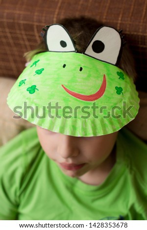 paper plate frog. hand made DIY painted paper hat on boys with green t-shirt head