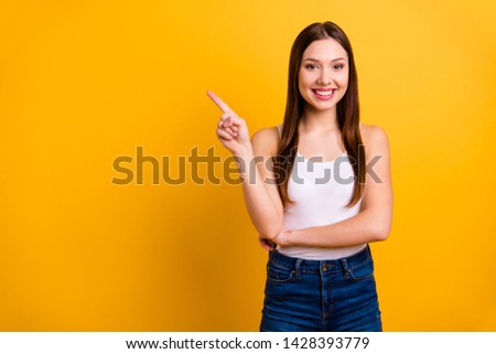 Close up photo beautiful she her lady perfect appearance hand arm index finger indicate empty space news advising buy buyer wear casual jeans denim white tank-top isolated bright yellow background