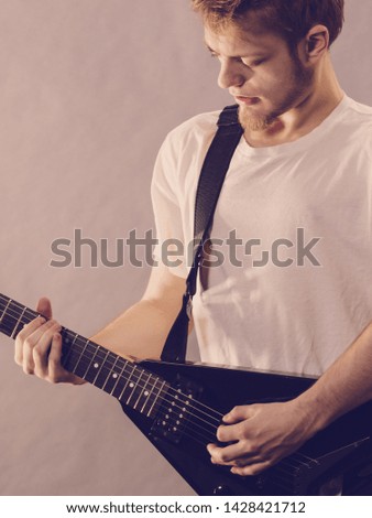 Man being passionate about his music hobby, playing electric guitar emotionally.