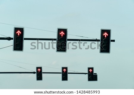 Many red traffic lights do not go ahead on the black pole.
