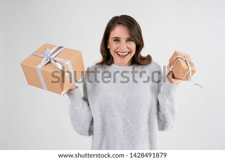Portrait of beautiful woman holding two gifts in studio shot 