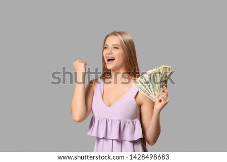 Happy woman with money on grey background