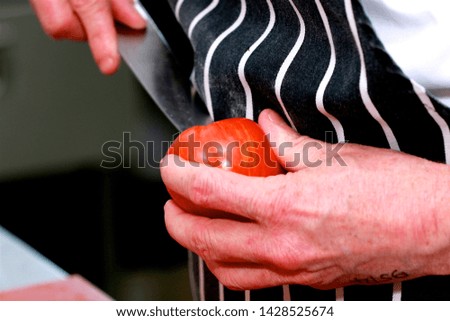 Close up shot of a chef preparing a tomato.