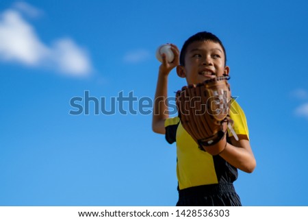 Blurred kids boy playing baseball on blue sky background