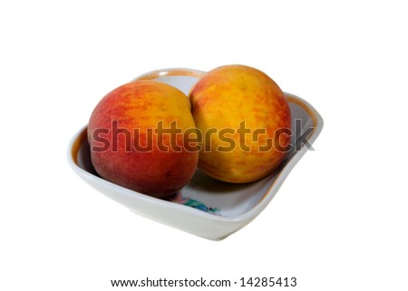 two peaches in the saucer. isolated on white.
