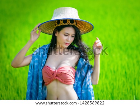 Farmer woman, portrait beautiful model in local Thai costume at the green rice field. 