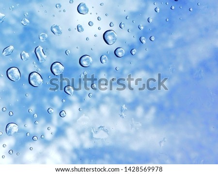 Rain drops on the surface of the car glass on the background of the cloud