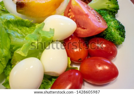 Boiled quail eggs ,Cherry tomatoes ,broccoli and Lettuce mix in salad dish