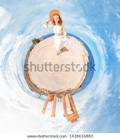 Happy traveler woman standing on a little planet and observing popular tourist landmark of ancient Acropolis in Greece. Unusual 360 degrees panoramic photo technique.
