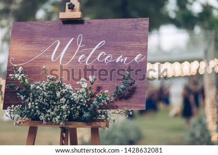 welcome sign wood with flowers , rustic wedding sign  on blur background and bukeh