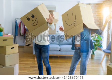 Funny couple wearing cardboard boxes with fun crazy emoji faces 
