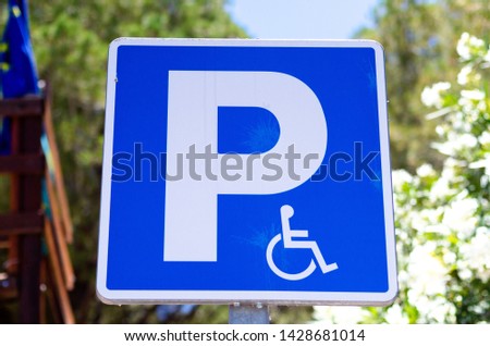 Traffic sign parking space for wheelchair users and disabled drivers. Blue fill with white text. Capital letter P and carriage sign for disabled people