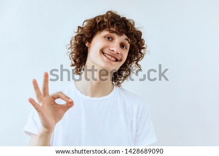 Okay symbol. Portrait of Curly young teen guy who a showing agree and approval sing. 